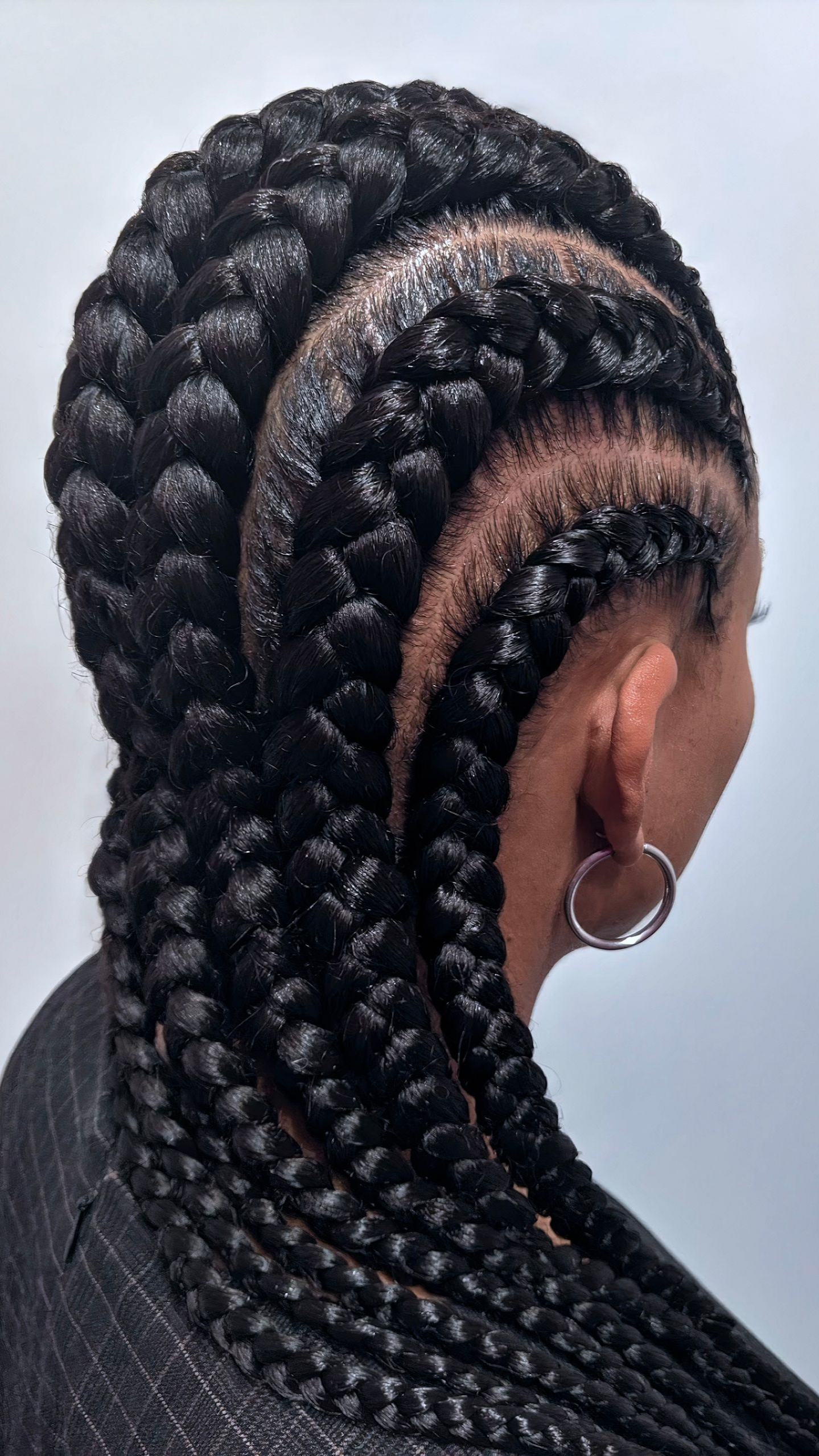 Gros plan sur la tête d'une personne aux cheveux noirs tressés avec des larges nattes africaines.