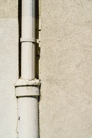 Un primer plano de una tubería blanca en el costado de un edificio.