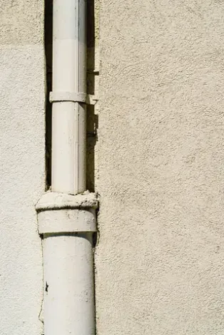 Un primer plano de una tubería blanca en el costado de un edificio.