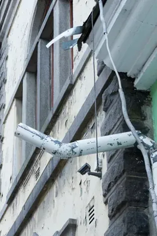 Un tubo blanco cuelga del costado de un edificio.