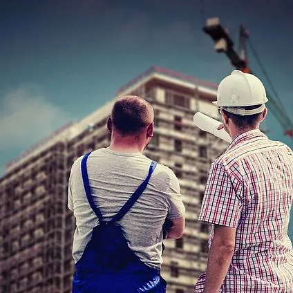 Dos hombres están parados frente a un edificio en construcción.