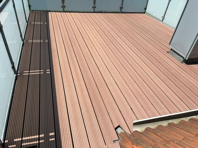 Ein Balkon mit Holzterrasse und Treppe