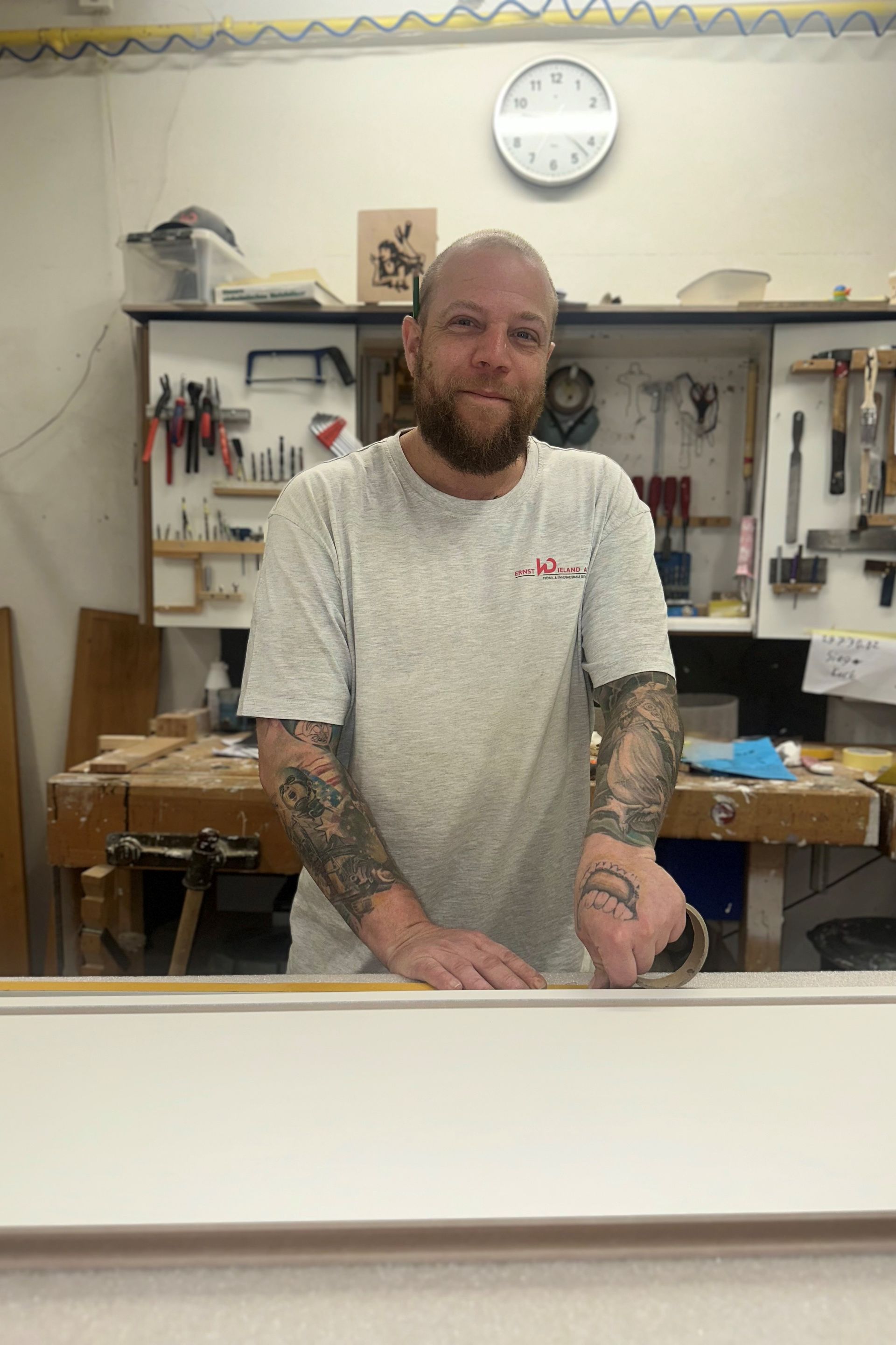 Ein Mann mit Bart trägt einen Hut und eine blaue Jacke