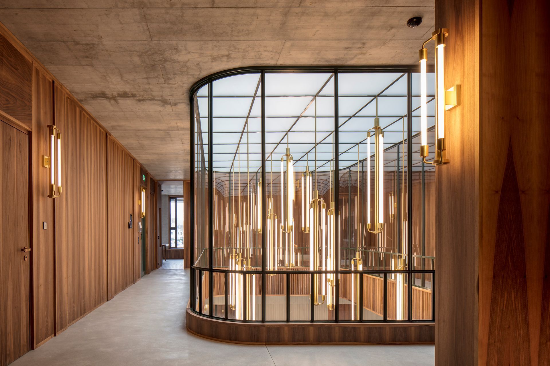 Ein langer Flur mit Holzwänden und einer Glaswand.