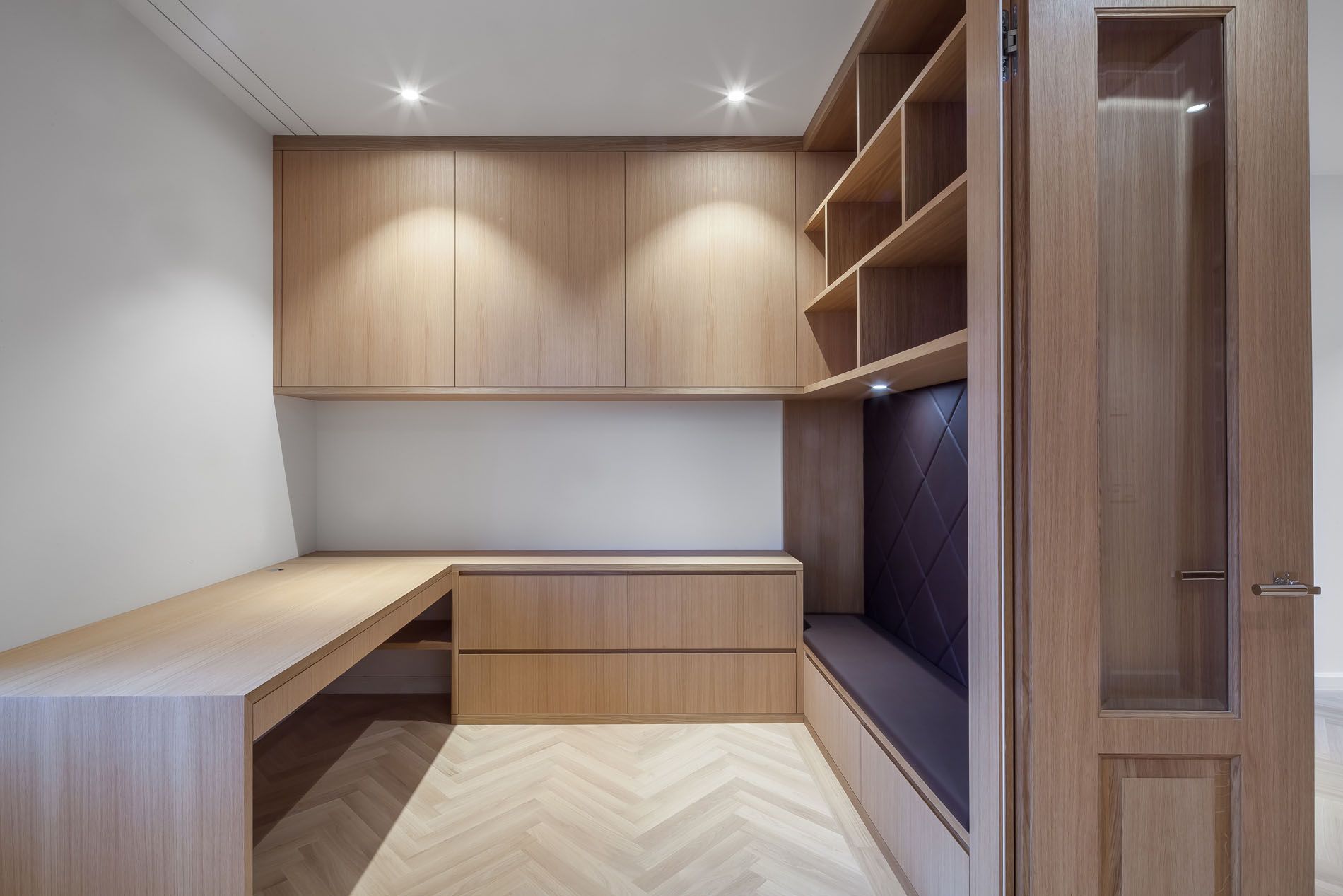 Ein Raum mit einem Schreibtisch, Regalen und einem Fenster.