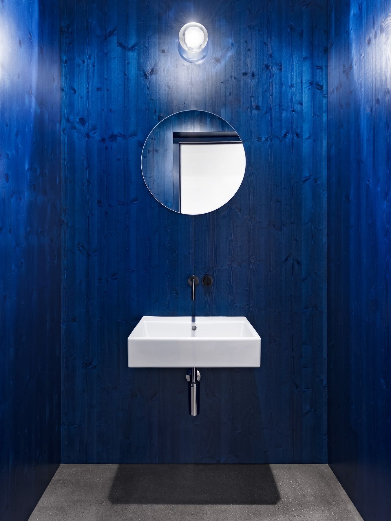 Ein Badezimmer mit Waschbecken, Spiegel und blauen Wänden.