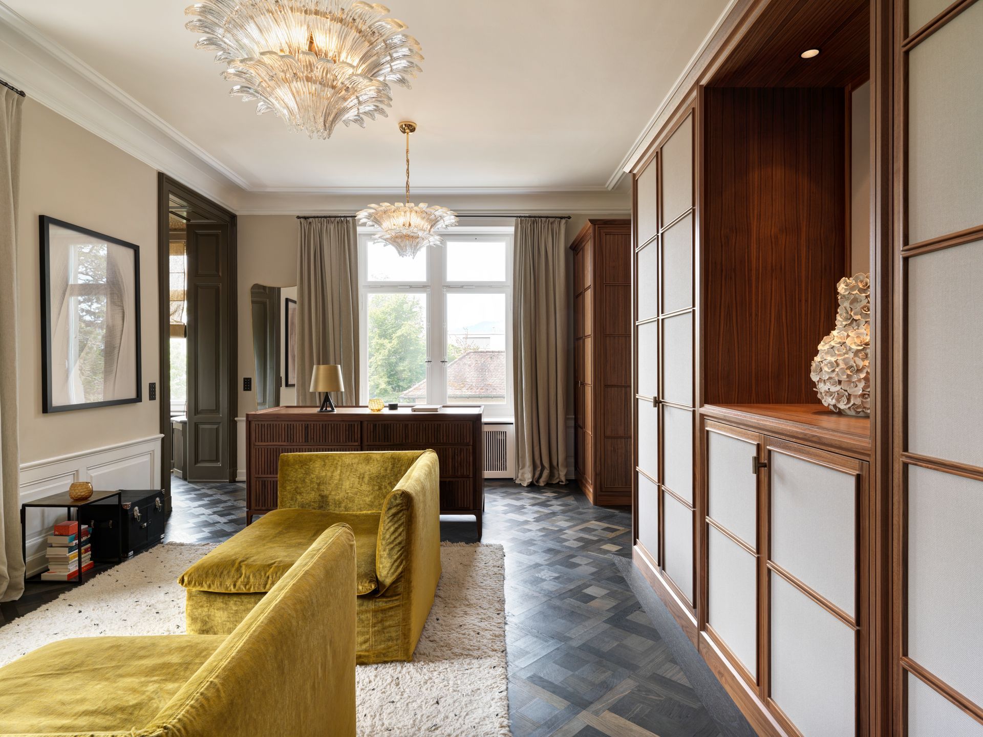 Ein Wohnzimmer mit gelben Möbeln und einem Kronleuchter, der von der Decke hängt.