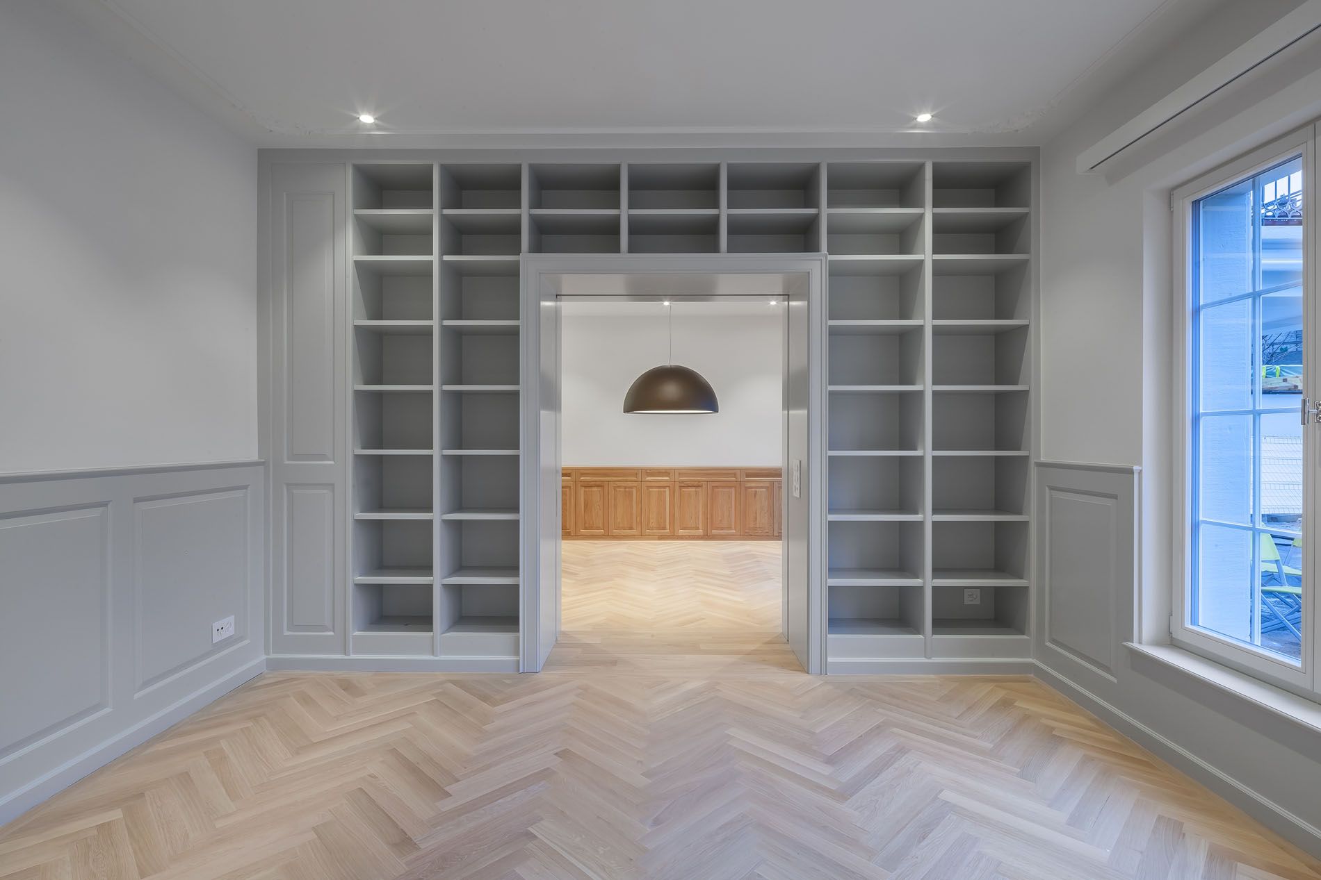 Ein leerer Raum mit vielen Regalen und einem Holzboden.