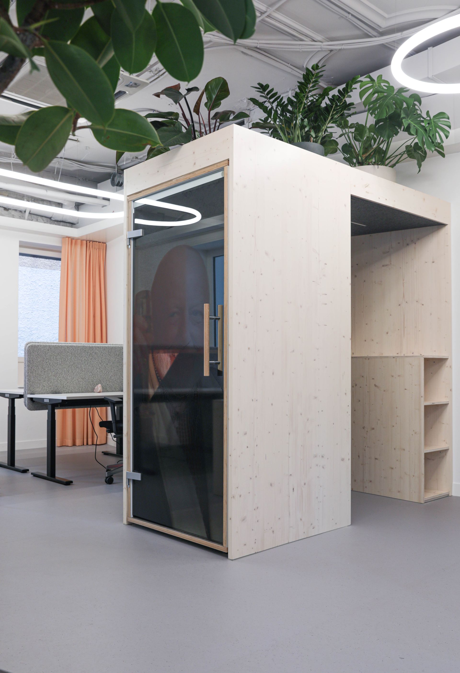 Eine Holzkabine mit Glastür in einem Büro.