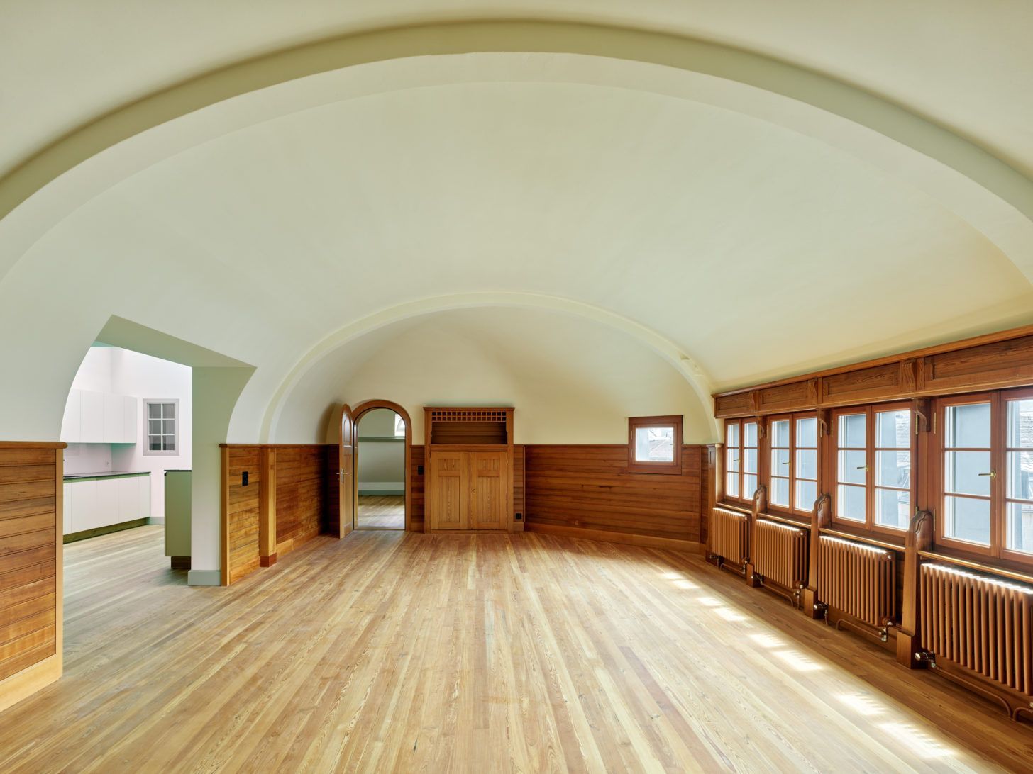 Ein leerer Raum mit gewölbten Decken und Holzböden