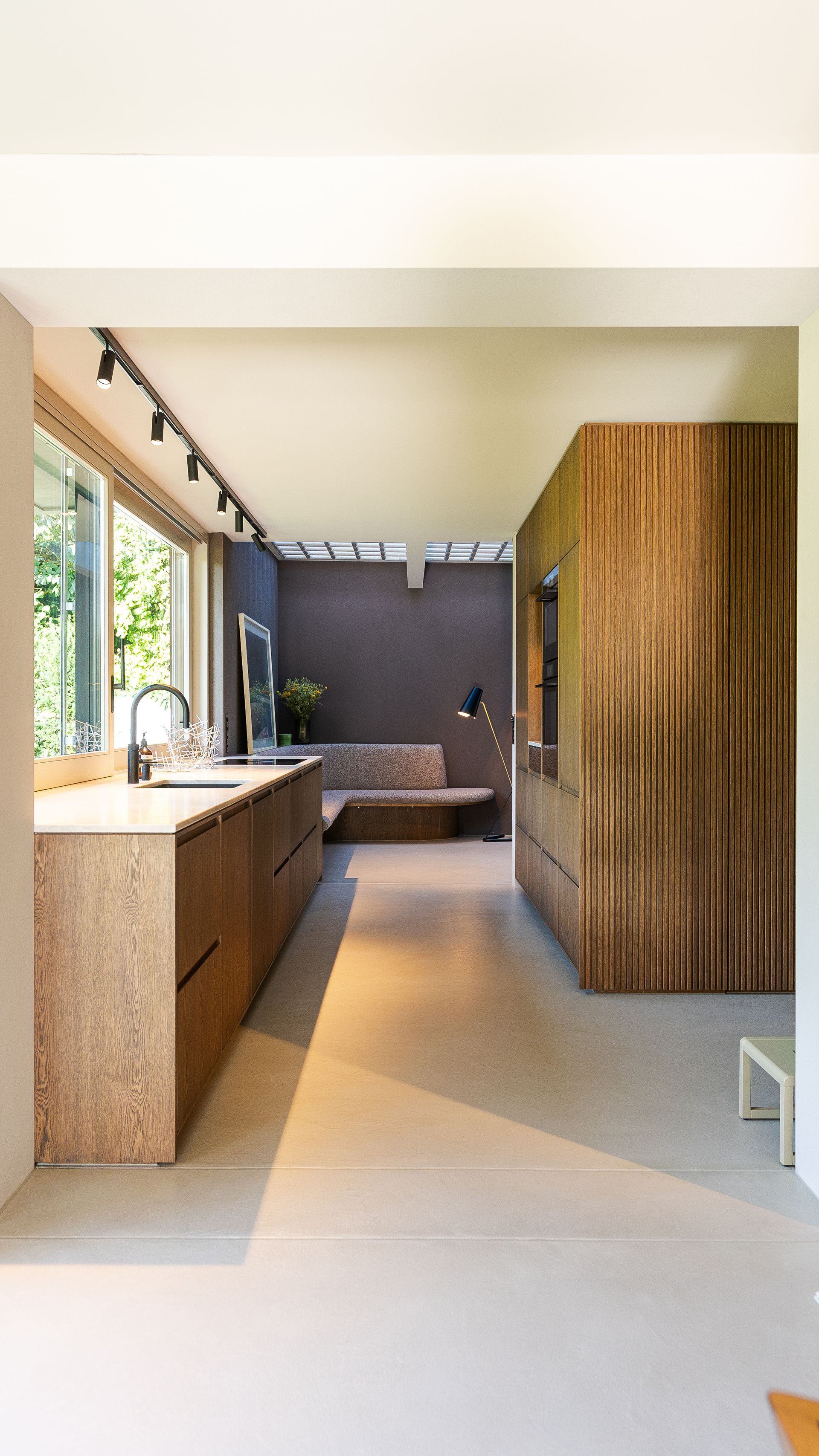 Eine Küche mit Holzschränken, einer Spüle und einer Couch.