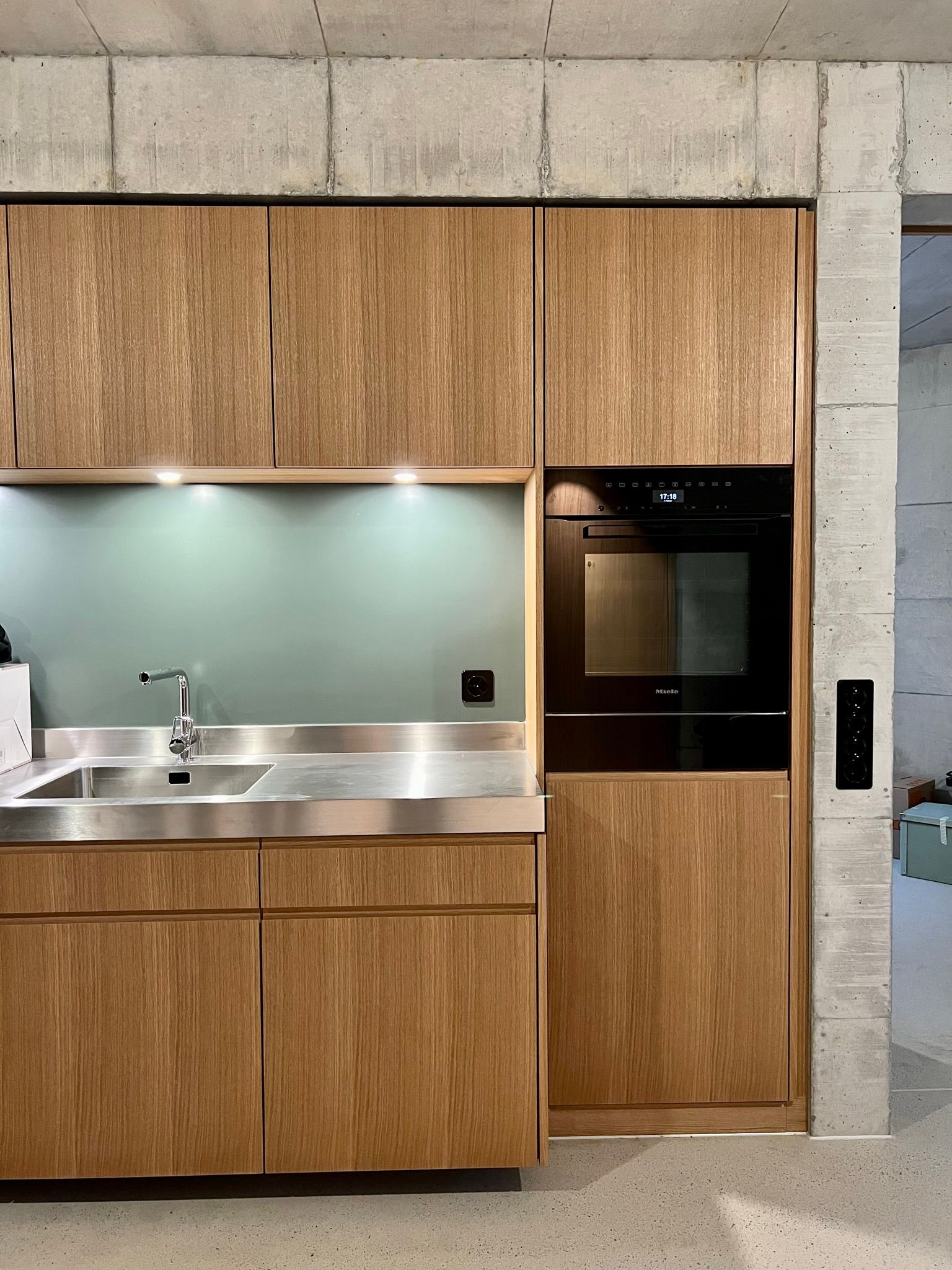 Eine Küche mit Holzschränken und einer Arbeitsplatte aus Edelstahl