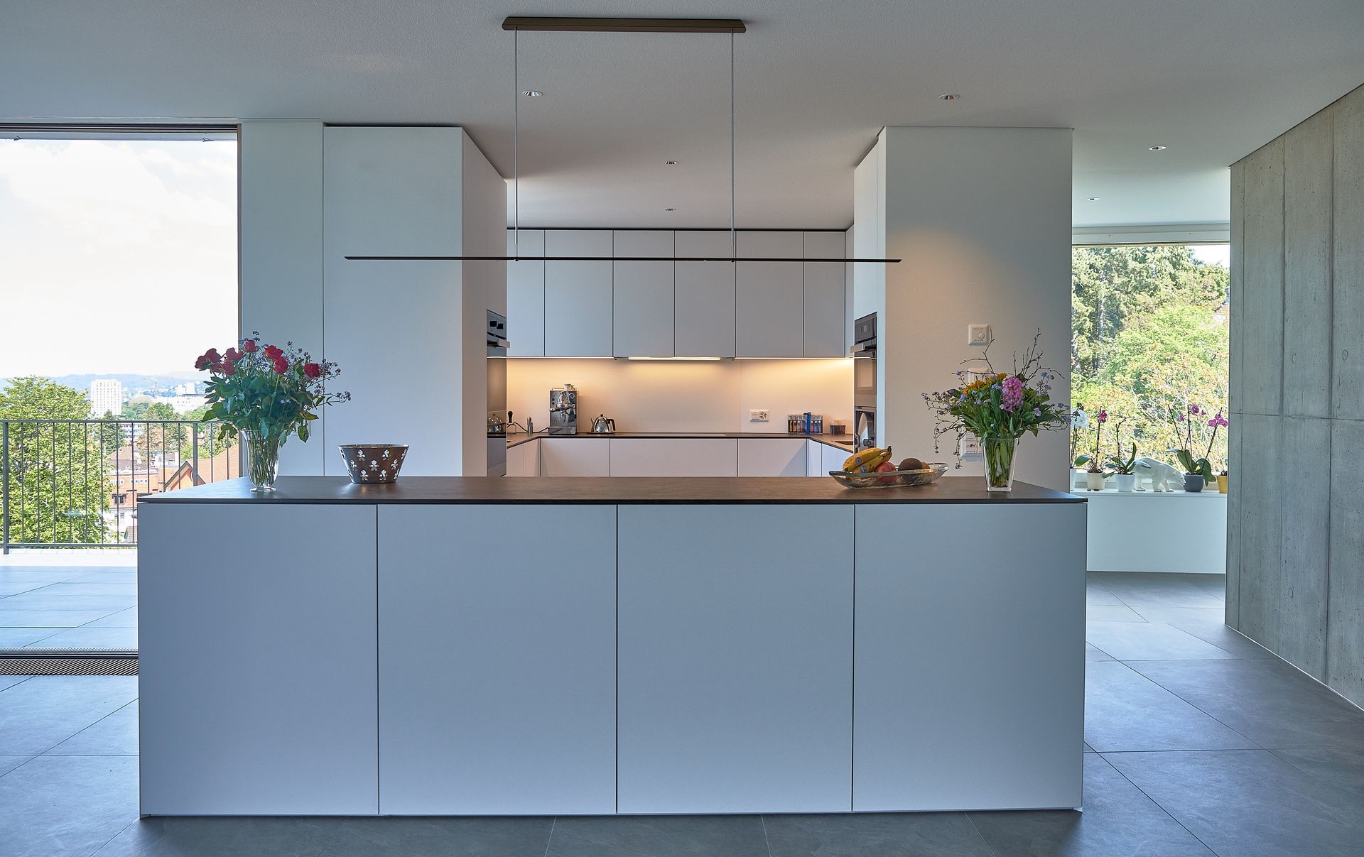 Eine Küche mit weißen Schränken und einer großen Insel in der Mitte.