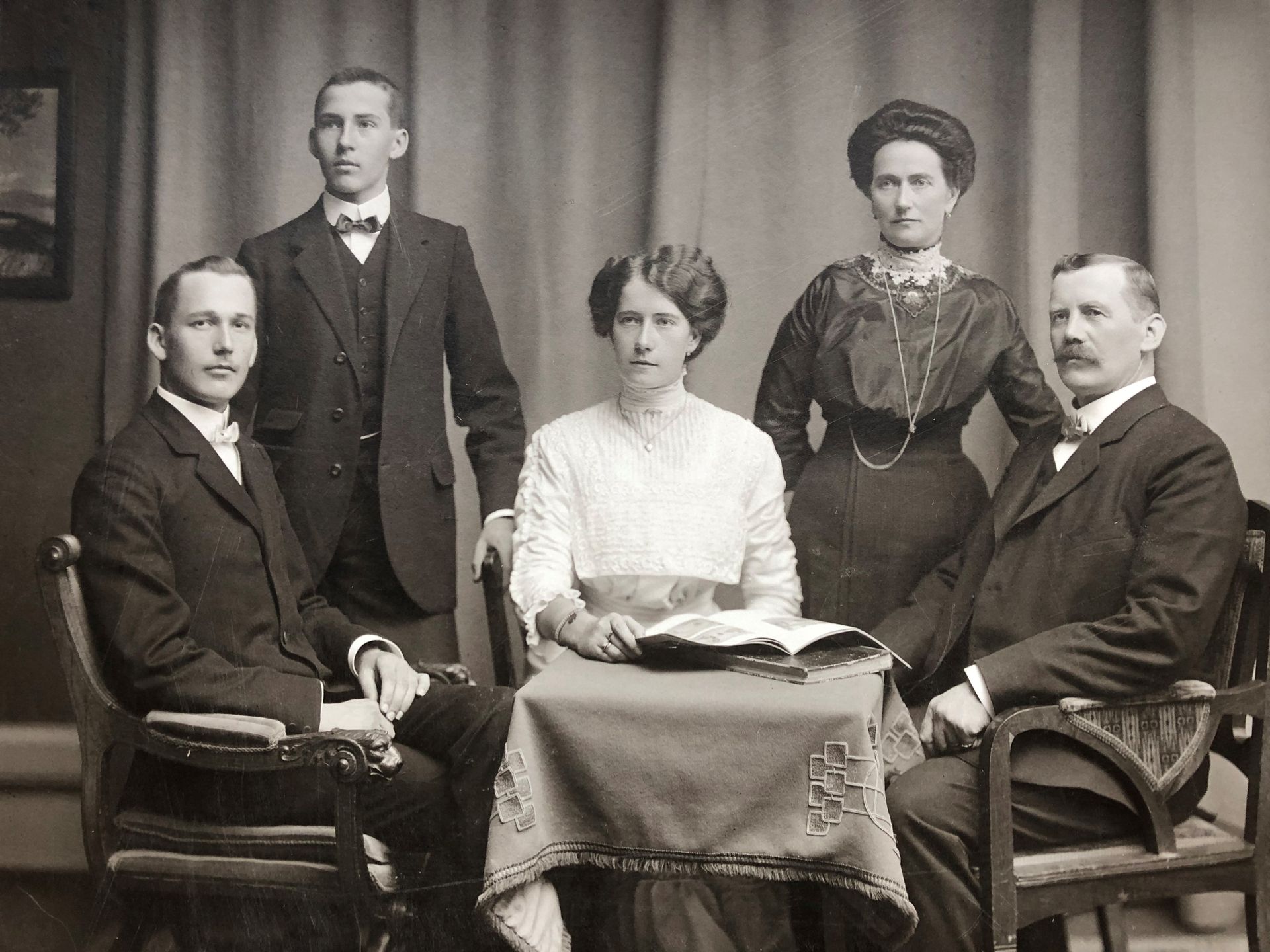 Ein Schwarzweißfoto einer Familie, die um einen Tisch sitzt