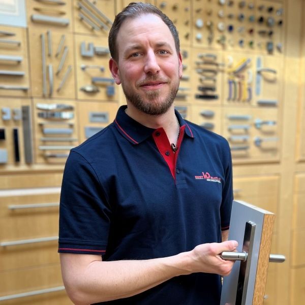 Ein Mann in einem blauen Hemd hält eine Türklinke