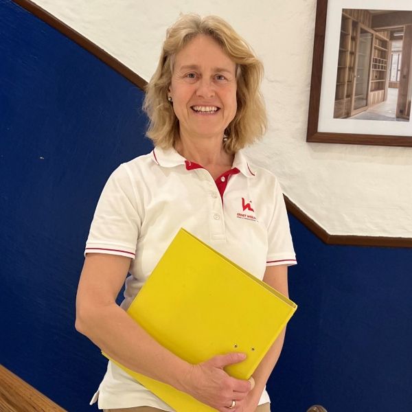 Eine Frau trägt ein weißes Hemd mit dem Buchstaben K darauf