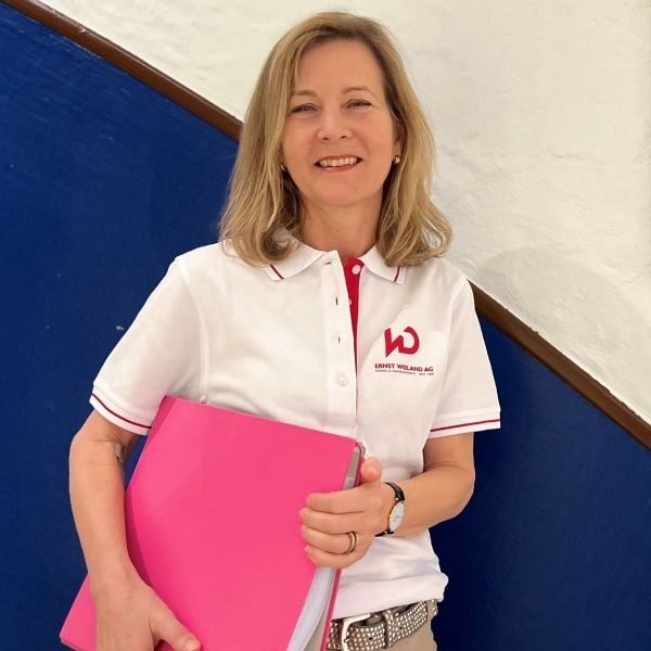 Eine Frau trägt ein weißes Hemd mit dem Buchstaben W darauf