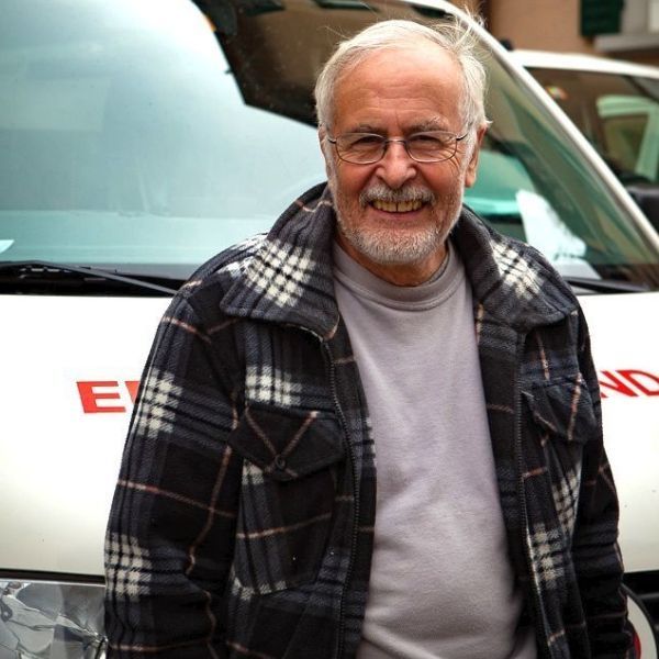 Ein Mann in einer karierten Jacke steht vor einem Express-Van