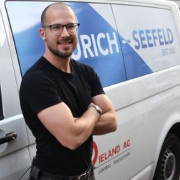 Ein Mann steht vor einem Lieferwagen mit der Aufschrift „Rich Seefeld“