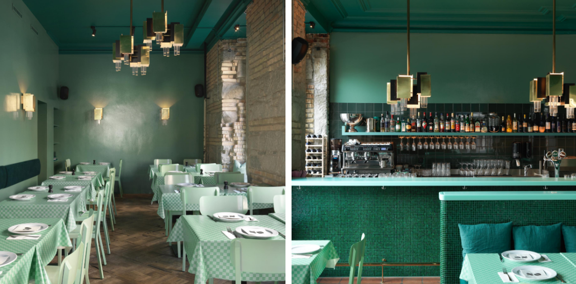 Ein Restaurant mit grünen Tischen und Stühlen und einer Bar.