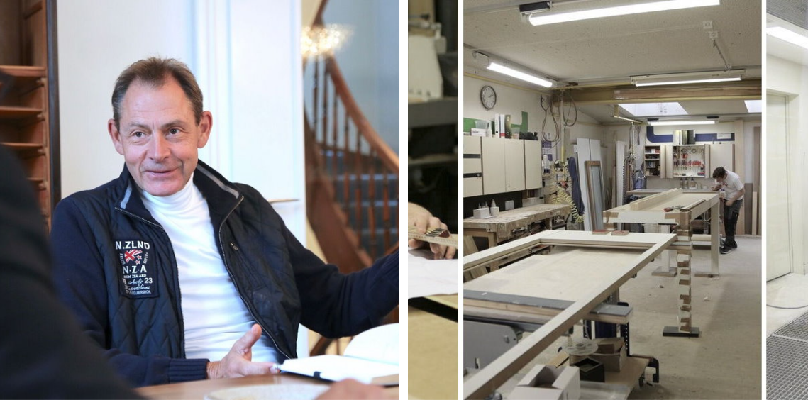 Ein Mann sitzt an einem Tisch in einem Raum neben einer Treppe.