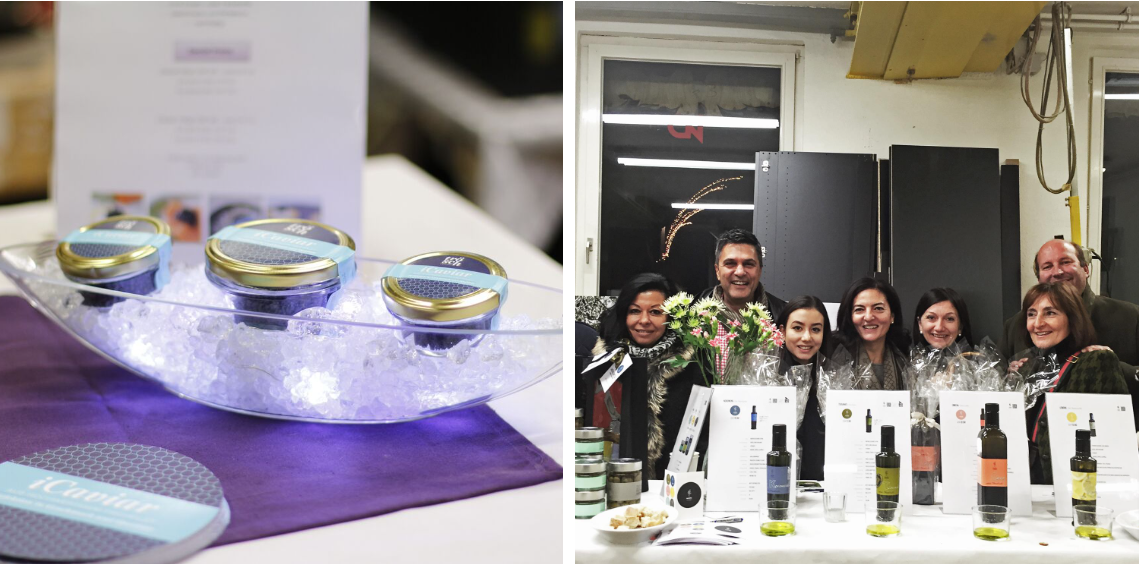 Eine Gruppe von Leuten steht mit Weinflaschen um einen Tisch herum.