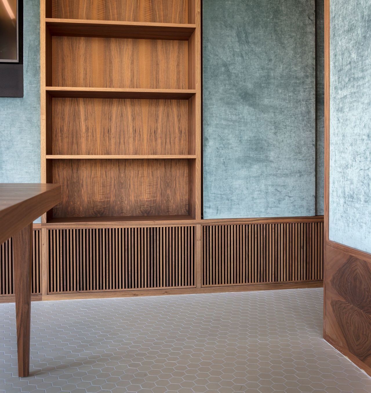 Ein Zimmer mit Holzregalen und einem Schreibtisch