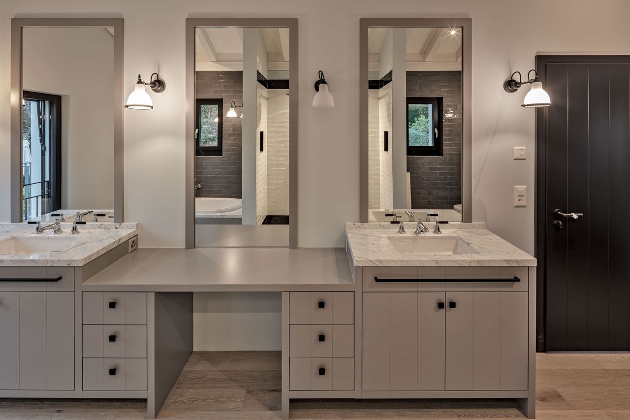 Ein Badezimmer mit zwei Waschbecken und zwei Spiegeln.