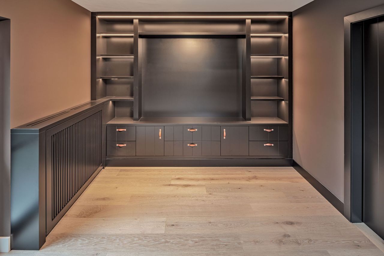 Ein Flur mit eingebautem Entertainment-Center und Regalen.