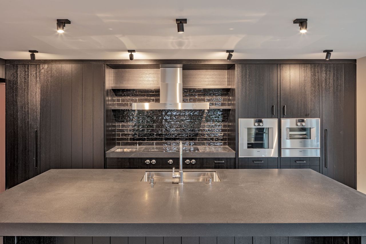 Eine Küche mit Geräten aus Edelstahl und einer großen Kochinsel.