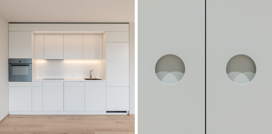 Eine Küche mit weißen Schränken und einem Bild einer Tür mit zwei Löchern darin.