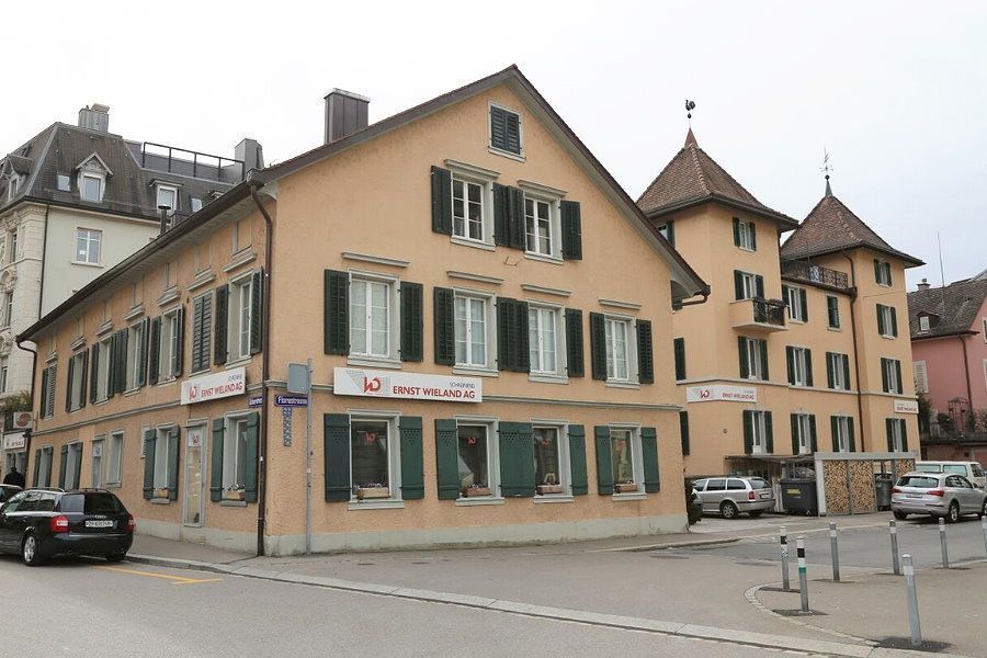 Ein großes Gebäude mit vielen Fenstern und einem davor geparkten Auto.