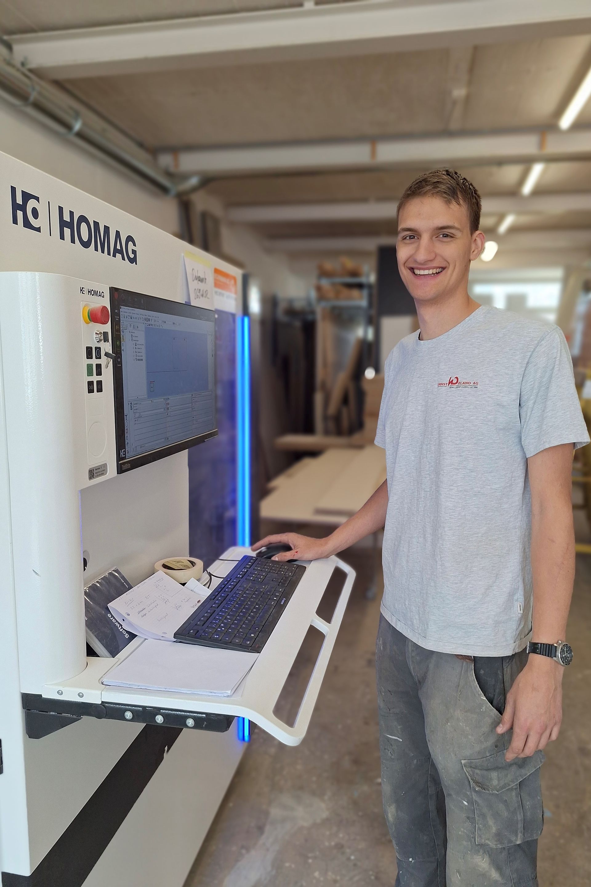 Ein Mann steht in einer Fabrik vor einem Computer.