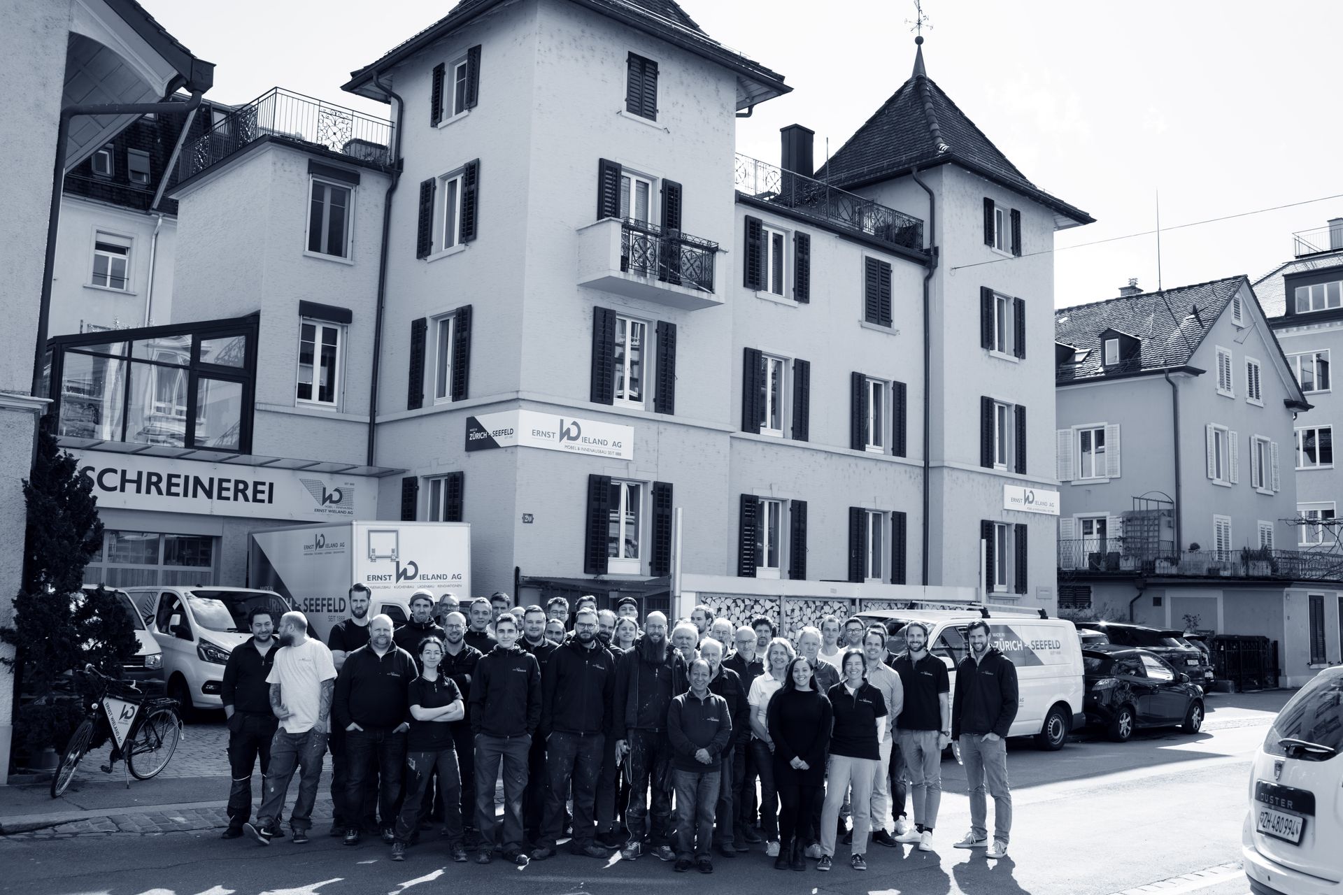 Eine Gruppe von Menschen posiert vor einem Gebäude für ein Foto.