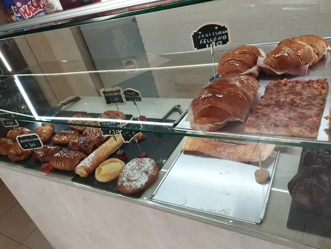 En una panadería se exponen diversos pasteles en vitrinas de cristal.