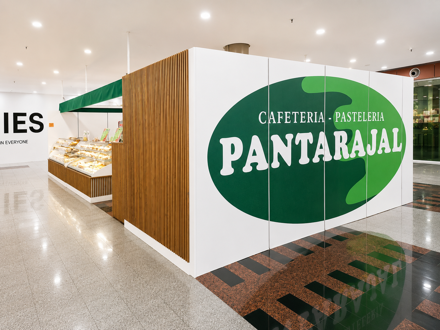 Mostrador de panadería con letrero verde de PANTARAJÁ y listones de madera en un luminoso interior de la tienda.