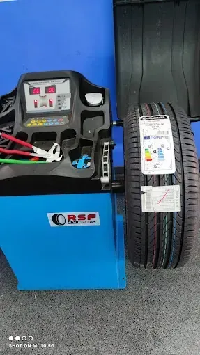 Una máquina equilibradora de neumáticos está situada al lado de un neumático.