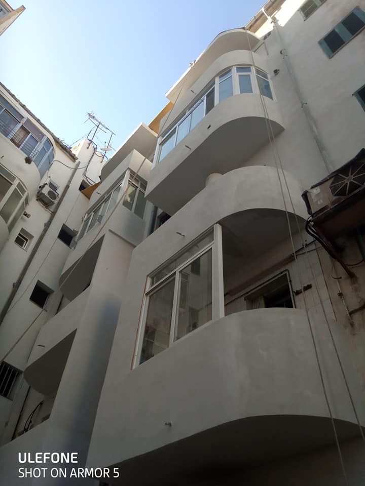 Un edificio blanco con muchas ventanas y balcones.