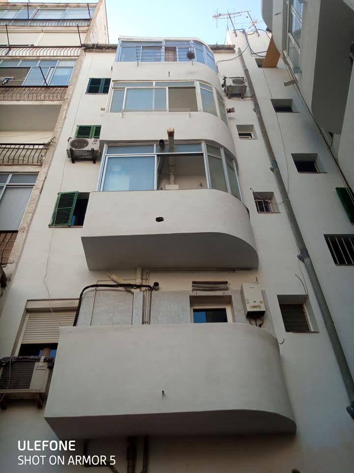 Un edificio blanco con muchas ventanas y balcones.