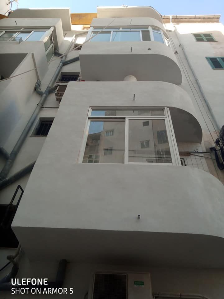 Un edificio blanco con muchas ventanas y balcones.