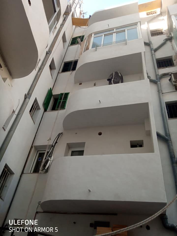 Un edificio blanco con muchas ventanas y balcones.