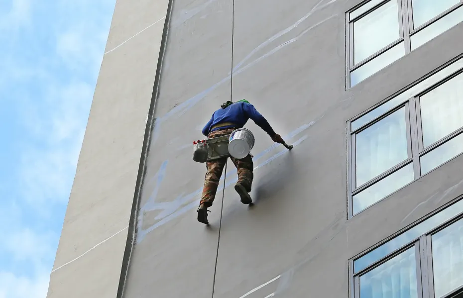 Un hombre está subiendo por el costado de un edificio.
