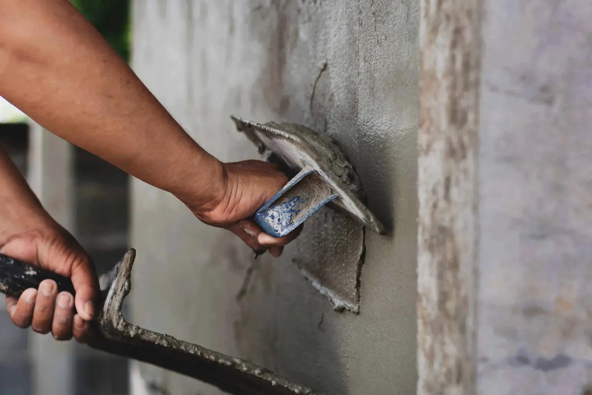 Una persona está enyesando una pared con una paleta.