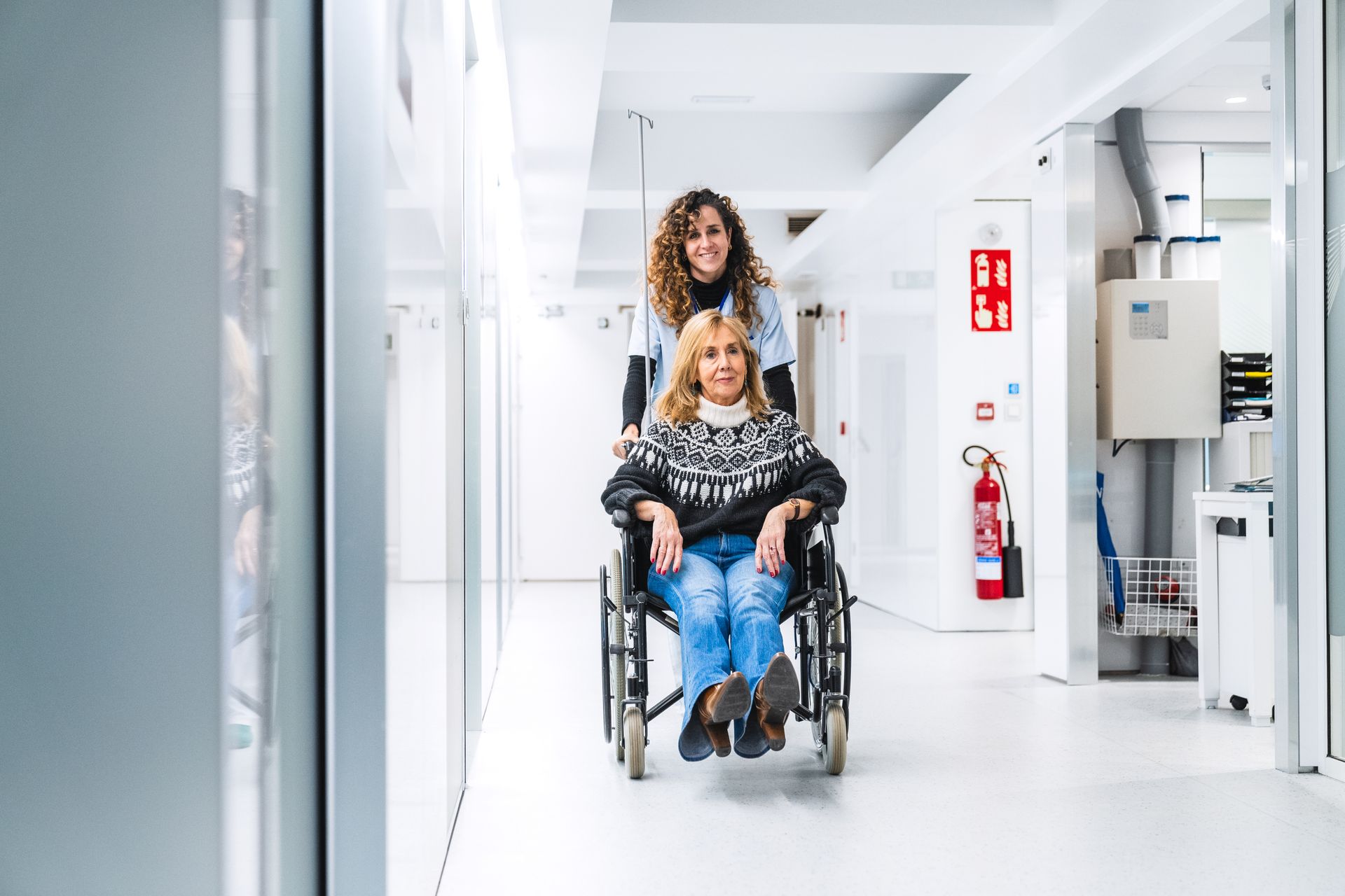 Uen femme qui sort d'un hôpital sur un fauteuil roulant.