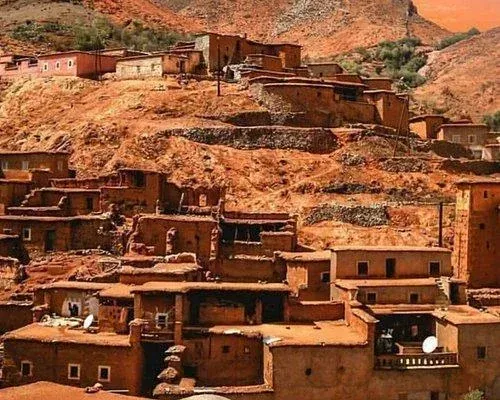 Escena callejera en Reykjavik, Islandia, con tiendas, gente, árboles y un monumento alto.
