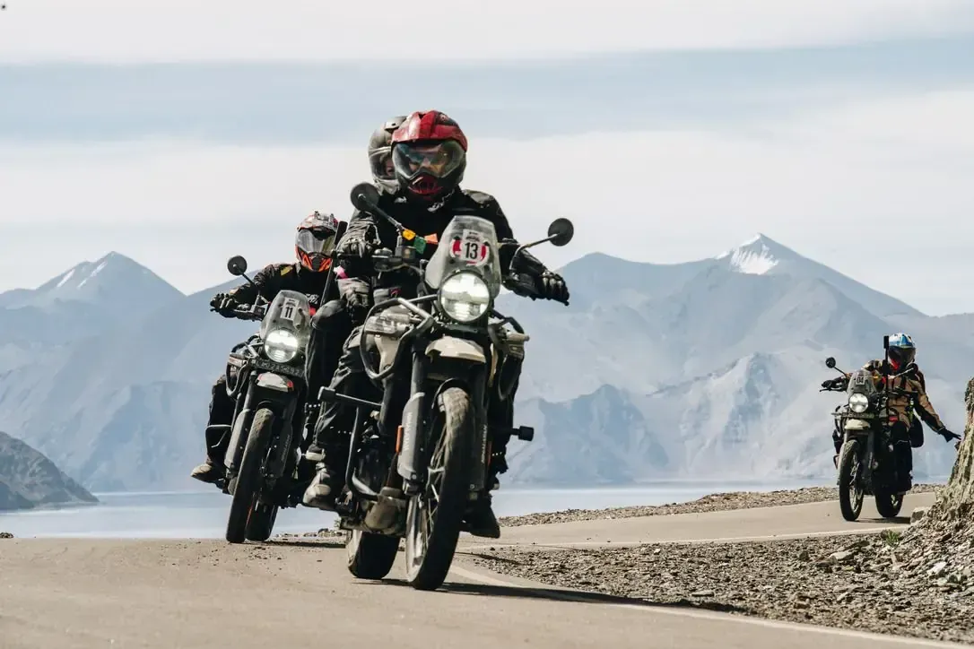 Montañas y valle bajo un cielo azul con nubes blancas.