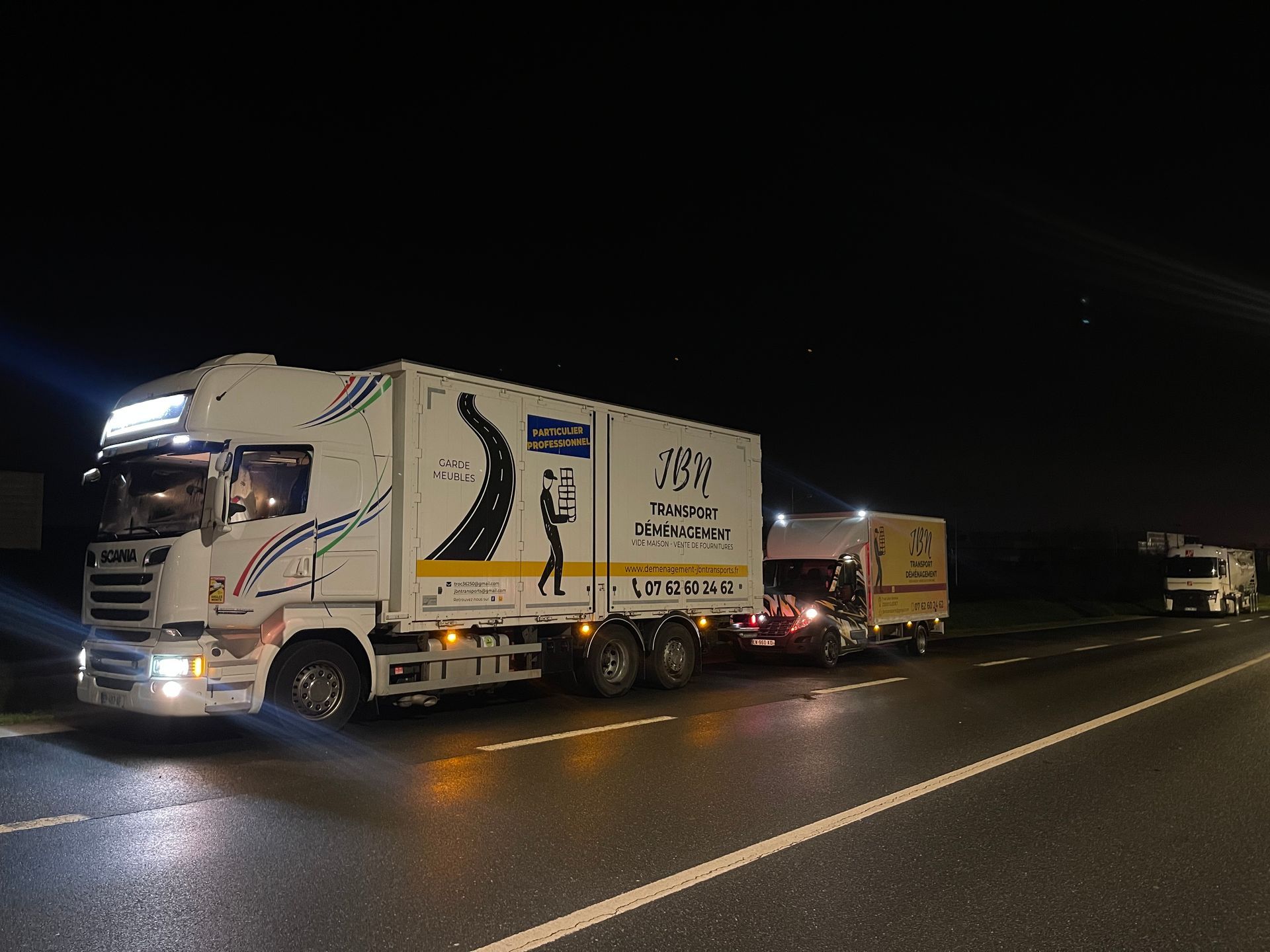 Parc de véhicules de déménagement roulant la nuit