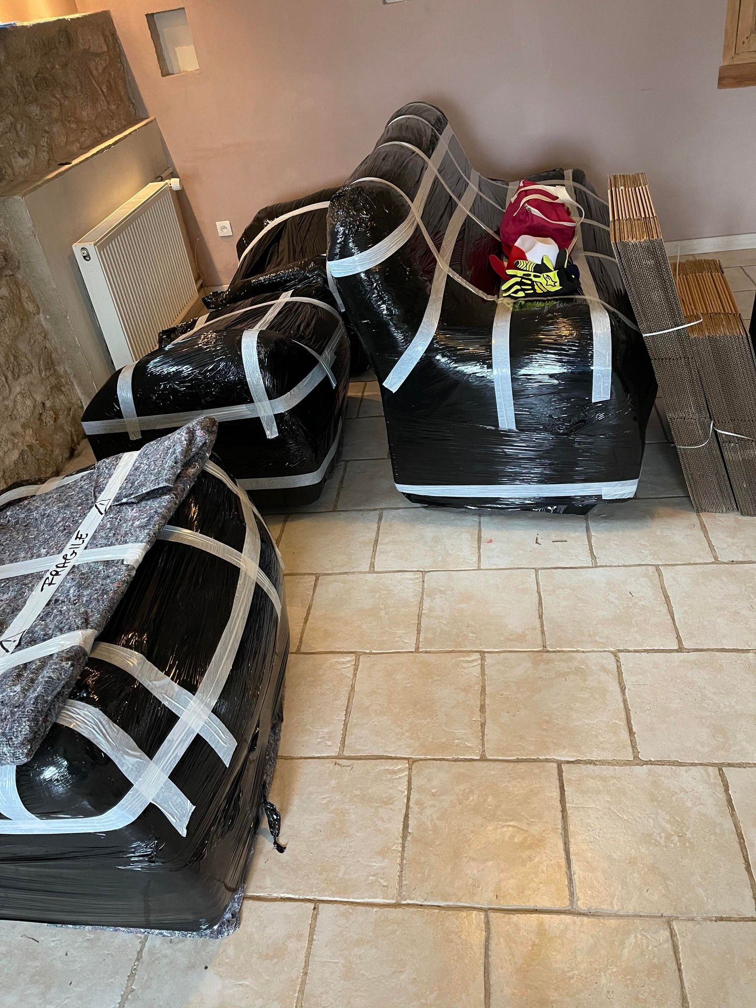 Mobilier et canapé emballés dans du plastique noir et scotch gris