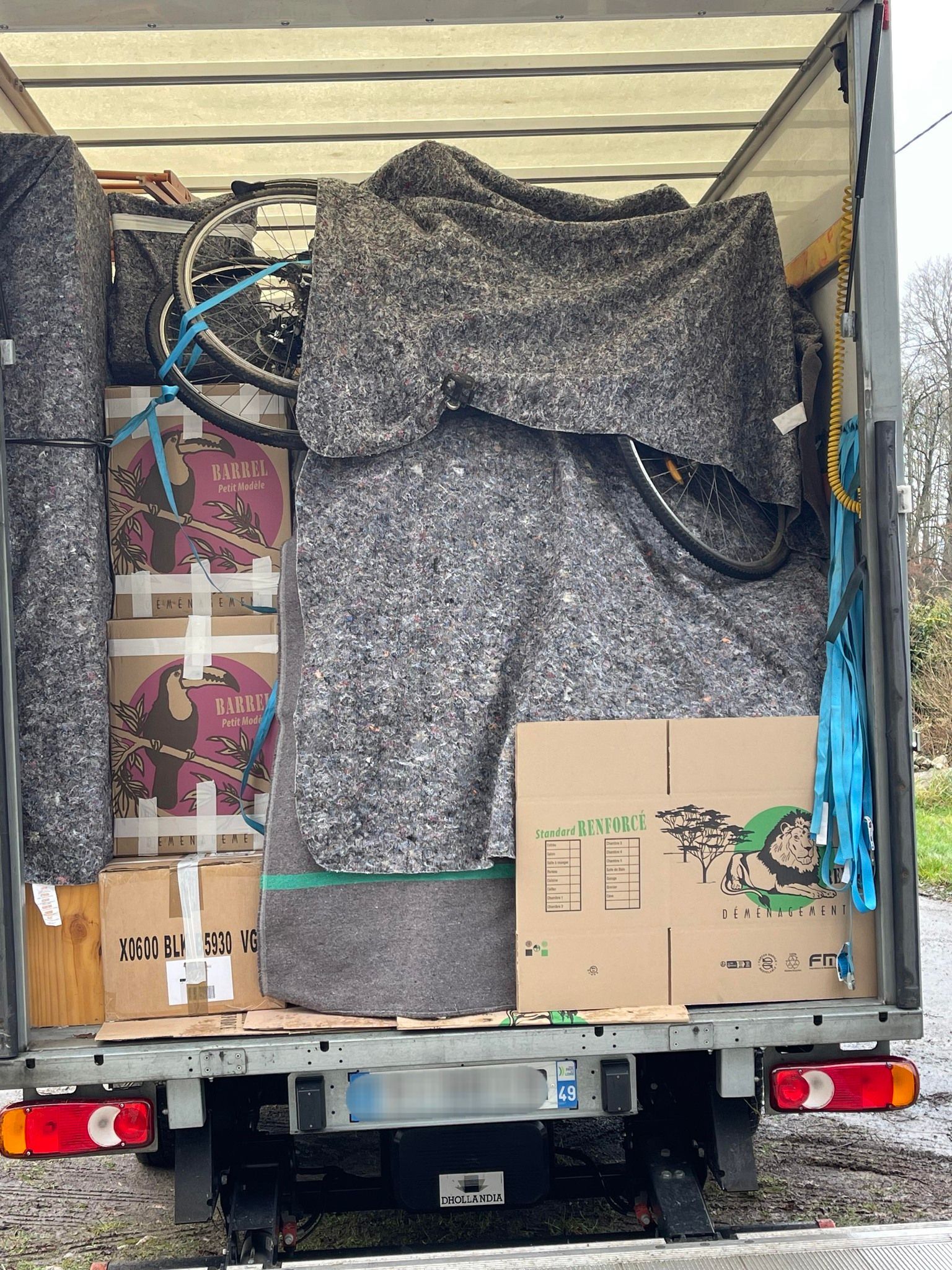 Camion de la société garé devant un bâtiment avec l'entrée éclairée