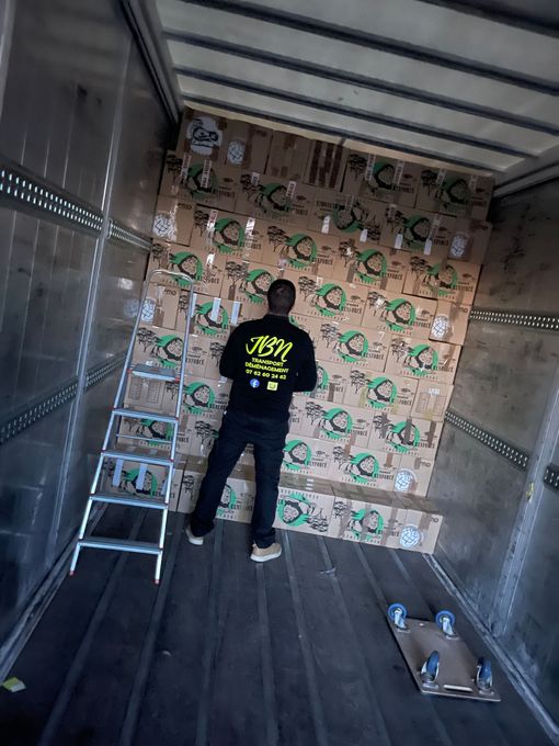 Déménageur portant une veste JBN Transport de dos dans un camion de déménagement